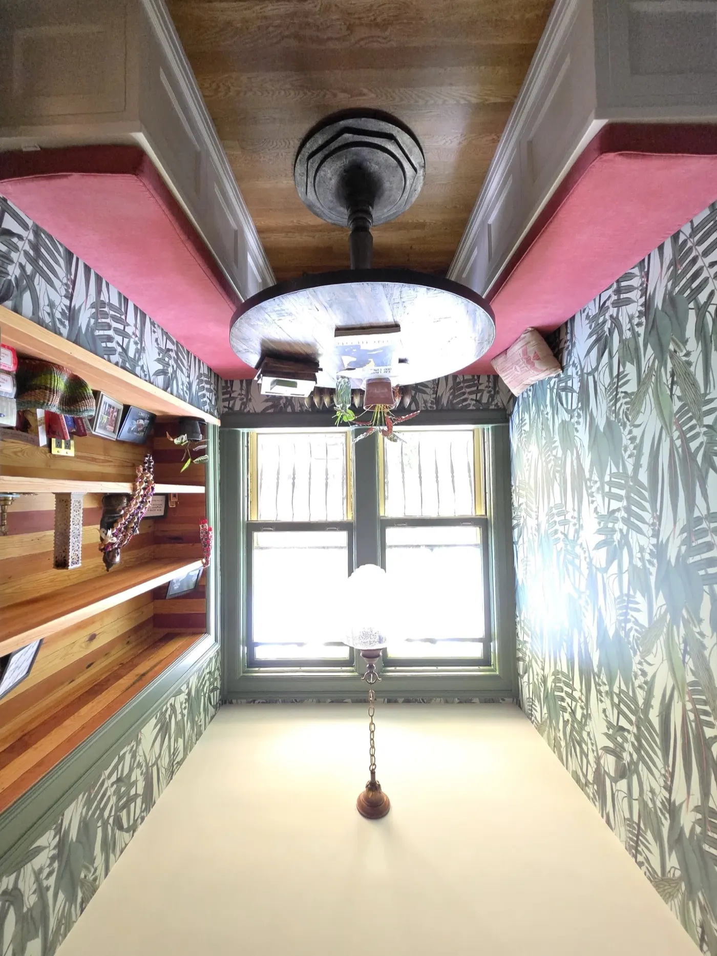 Room after — botanical wallpaper, custom shelving, built-in seating